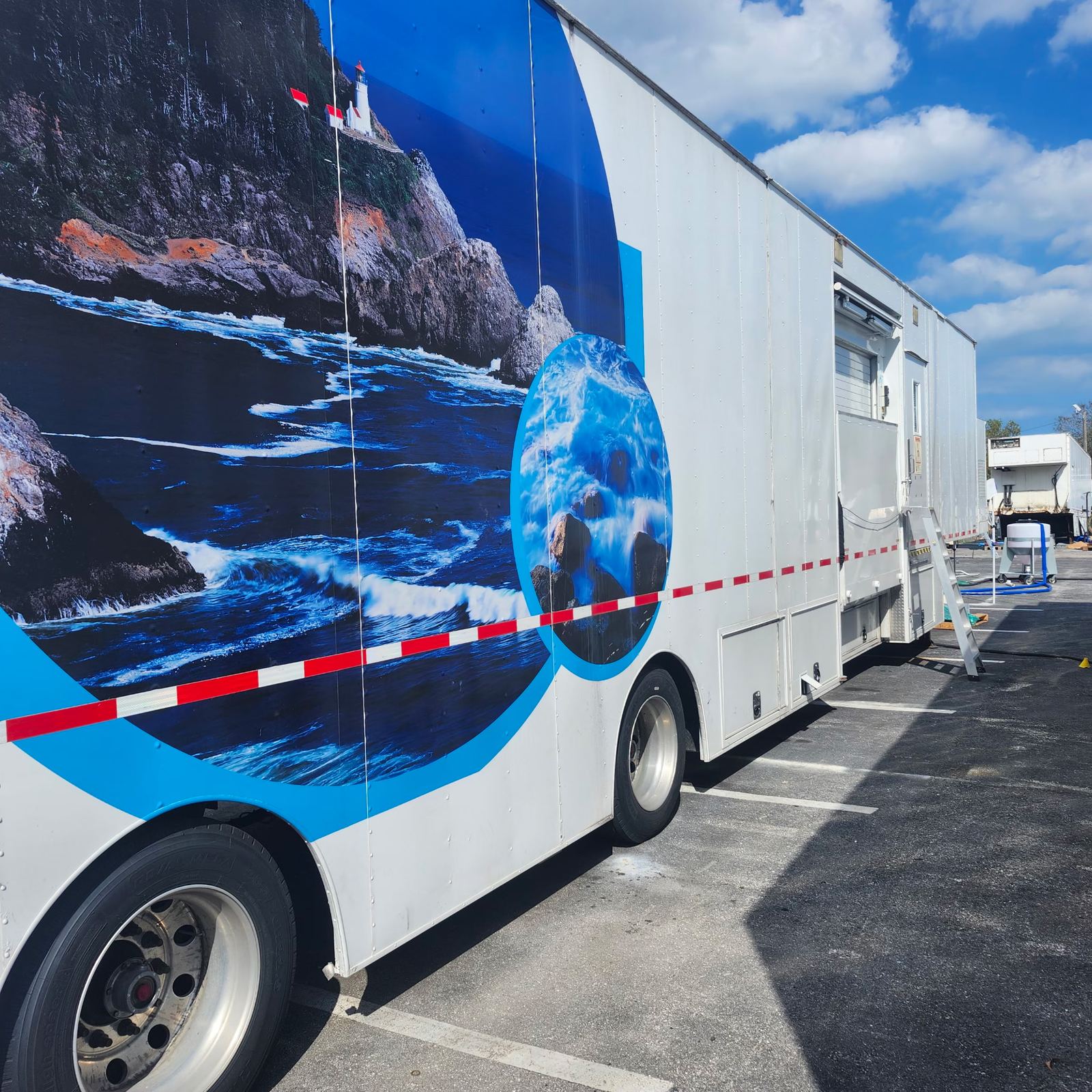Pinnacle Health mobile imaging trailer with a blue and white coastal-themed exterior wrap, parked in a lot