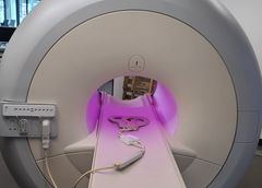Philips MRI bore illuminated in purple with a knee coil resting on the patient table